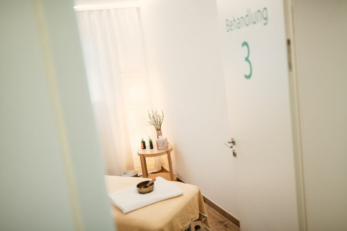 Behandlungsraum der Privatpraxis mit Massageliege und Klangschale